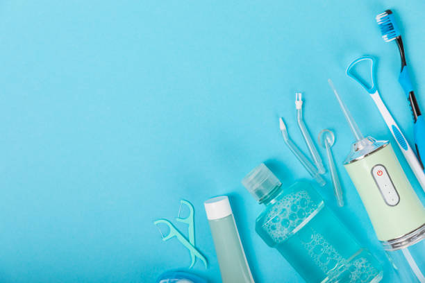 istock Electronic oral irrigator, toothbrush, paste, dental floss and mouthwash on a blue background. Dental tool for oral hygiene. Electric Interdental Cleaner. Dental water shower. Oral care concept. 1557673500
