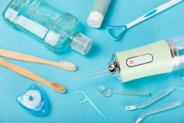 istock Electronic oral irrigator, toothbrush, paste, dental floss and mouthwash on a blue background. Dental tool for oral hygiene. Electric Interdental Cleaner. Dental water shower. Oral care concept. 1557682318
