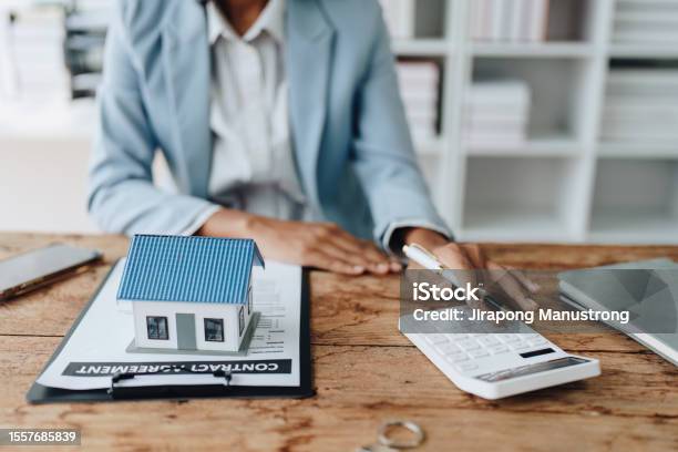 Real Estate Agent African American Businesswoman Africans Use Smartphone And Calculators To Offer Mortgages To Their Clients Home Mortgage And Insurance Finance Concepts Stock Photo - Download Image Now