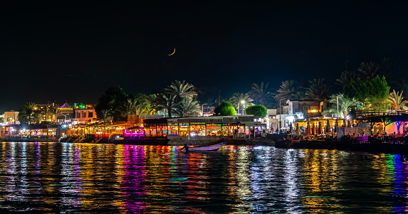 In the evening, the embankment of the Egyptian resort town of Dahab is filled with tourists relaxing in beautifully lit restaurants.