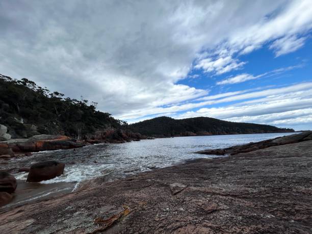 Moving Clouds in Honeymoon Bay Honeymoon Bay located in Freycinet National Park, Tasmania. honeymoon bay stock pictures, royalty-free photos & images