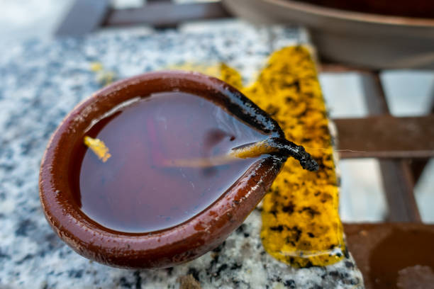 A traditional clay oil lamp or DIYA. The diya is filled with oil or ghee (clarified butter) and has a cotton wick that is lit to produce a small, flickering flame.