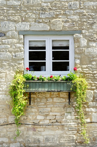Window with flowers on a stone house - countryside