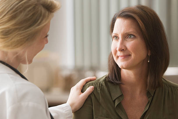 médica a falar com o paciente - mature adult women care listening imagens e fotografias de stock