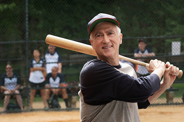 Senior man swinging bat New York City men baseball baseball cap baseball bat stock pictures, royalty-free photos & images