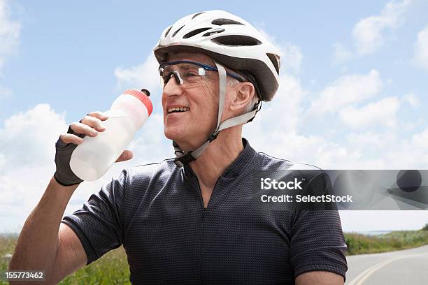 Senior Hombre Tomando Agua Descanso De Ciclismo Foto de stock y más banco de imágenes de Plástico - Plástico, Tercera edad, Botella de agua