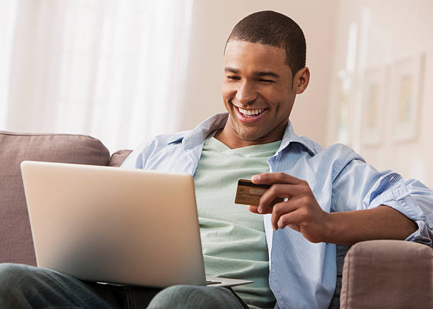 jovem adulto homem fazendo compras on-line - internet e mail paying credit card imagens e fotografias de stock