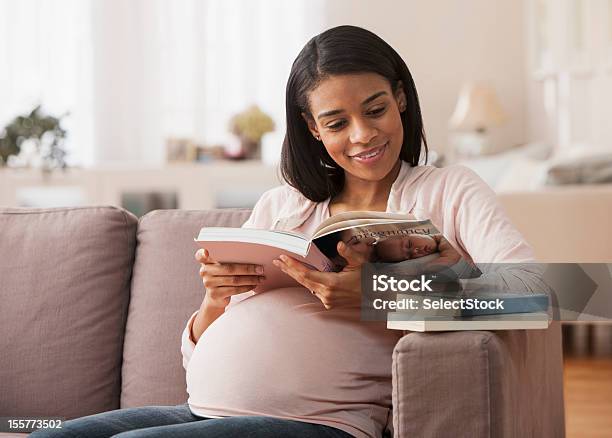 Mujer Embarazada Leyendo Un Libro Sentado Foto de stock y más banco de imágenes de Embarazada - Embarazada, Leer, Mujeres