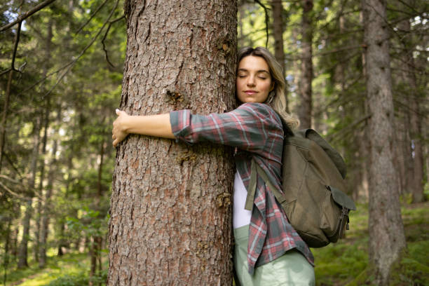 istock Young female tourist embracing the tree in nature. 1557735452