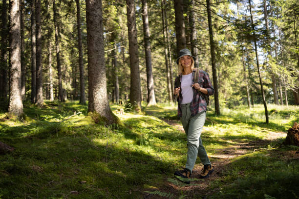 istock Happy female backpacker enjoying while hiking through the woods in springtime. 1557737266