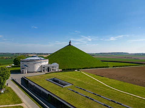 Aerial view farm field, Lion's Mound, Battle field, Napoleon, Waterloo, Belgium, green and sky, season. Aerial View at the Waterloo Hill with the statue of the lion of Memorial Battle of Waterloo, Belgium. Aerial landscape view shot by a drone.