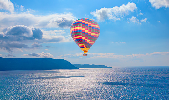 Colorful hot air balloon flying over serene sea