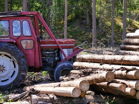 a tractor stands by a pile of lumber
