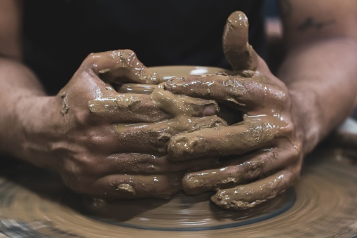 A close-up shot of a skilled artisan's hands deftly creating a unique vase from a lump of clay