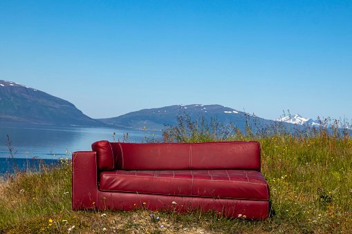 Red sofa on the background of mountains, Norvay