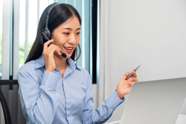 istock Female call center operator with headset working on support hotline in modern office Teleconferencing via video. online training. 1557768966