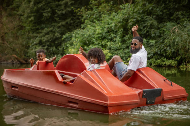 Black Father and two Sons having fun on a water bike on the water