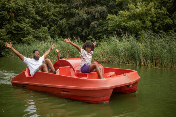 Black Father and two Sons having fun on a water bike on the water