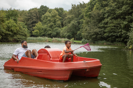 Black Father and two Sons having fun on a water bike on the water
