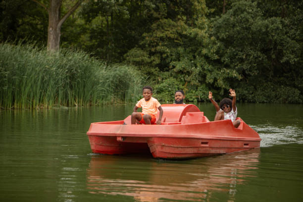 istock Father and Sons having pedal boat fun on the water 1557780088