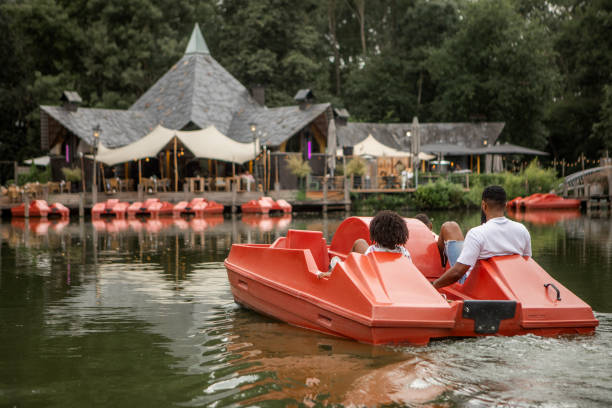 Black Father and two Sons having fun on a water bike on the water