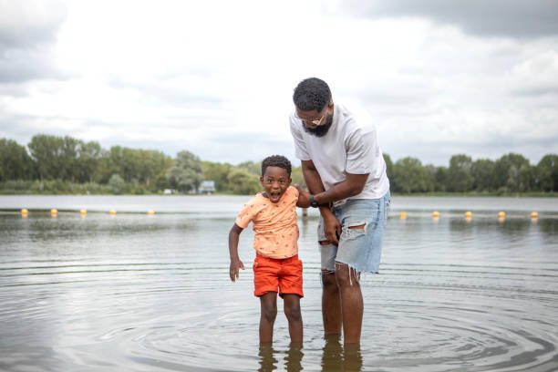 istock Father and Sons having fun on the water's edge 1557781709