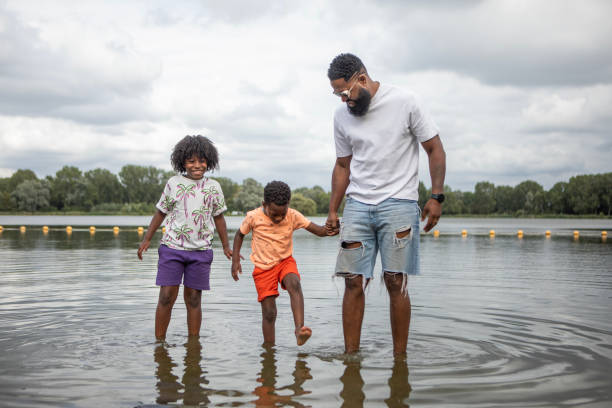 istock Father and Sons having fun on the water's edge 1557782216