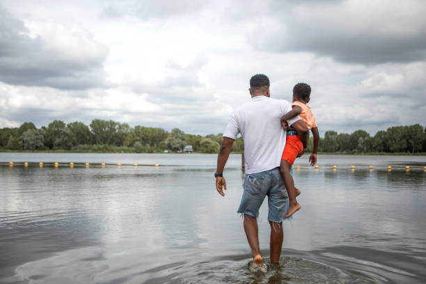 istock Father and Sons having fun on the water's edge 1557782220