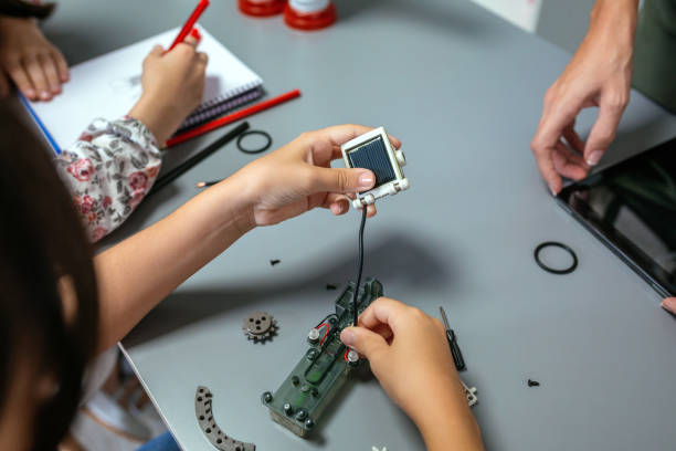 Female student connecting solar panel to electrical circuit in a robotics class stock photo