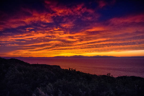 istock sunset on the top of a mountain covered with grass 1557793819