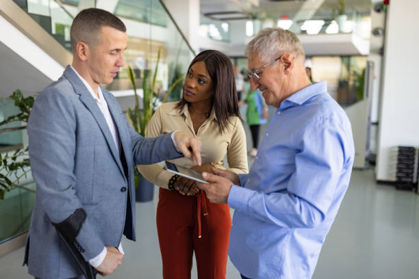 istock Business professionals talking in a lobby 1557794880