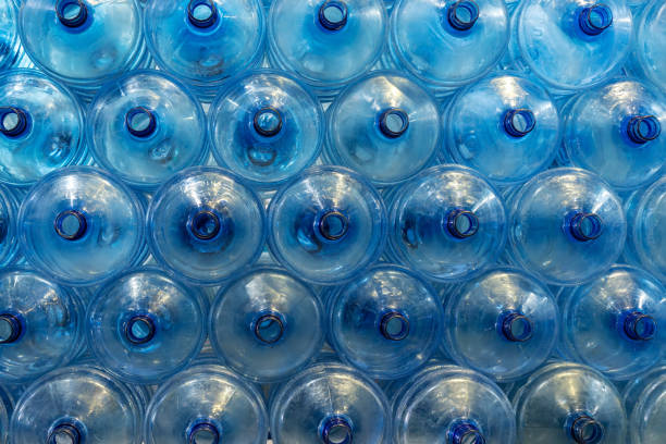 istock Gallon-sized plastic drinking water bottles arranged in a neat and orderly manner within a mineral water factory. Bottles await the filling process, representing the initial stage of production. 1557794882