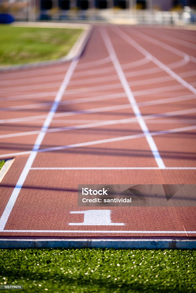 Primer carril izquierdo en una pista de atletismo - Foto de stock de Caja de salida de caballos libre de derechos