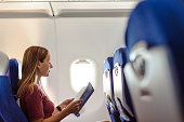 Woman traveling by plane and reading a magazine