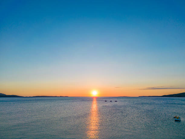Pastel sunrise over the Mediterranean sea. Drone point of view with three boats anchored.