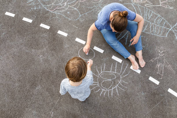 istock Young boy doodling the asphalt with a chalk 1557862493