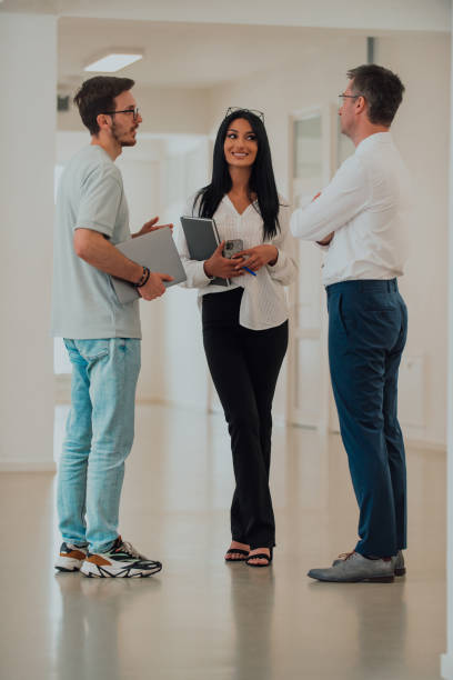 istock The director conducts a conversation with the secretary and a young programmer in a modern and spacious corridor of a large company, discussing various business topics and projects. 1557866791