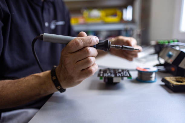 istock Male Technician Soldering Gadget 1557879021