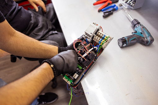 With a determined expression, a technician works diligently on repairing a device, driven to succeed.