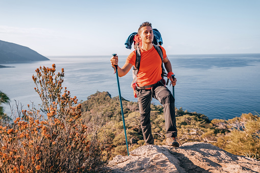 With a big smile on his face, a hiker embraces the beauty of the Lycian Way trail from a picturesque viewpoint. Travel and solo adventure in Turkey