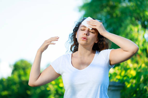 istock Young woman having hot flash and sweating in a warm summer day 1557892420