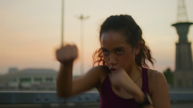 Female  doing shadow boxing in bayside public park