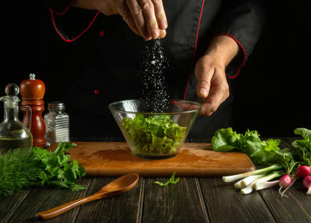 istock The cook salts chopped lettuce leaves in a plate. Working environment in a restaurant kitchen. Delicious salad with fresh vegetables. 1557921123