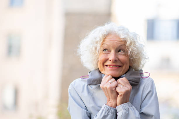 istock Close up smiling older woman cold with winter jacket 1557950112