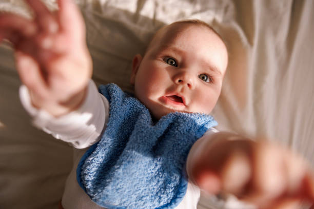 istock Playful baby boy reaching towards the camera 1557963949