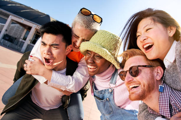 istock Multiracial group of students hugging having fun laugh a lot laugh outdoors the university campus 1557969414