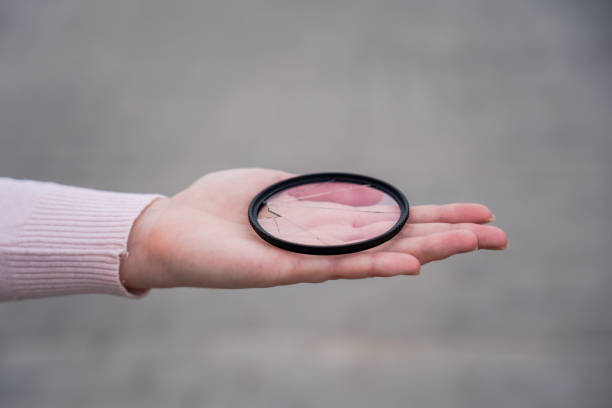 istock Broken lens filter in hand. Cracked photo-filter 1557975204