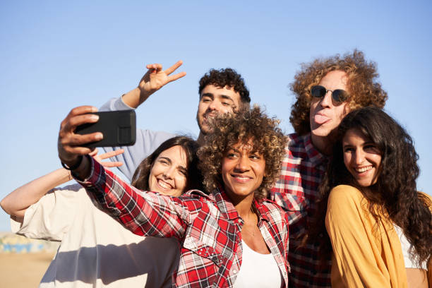 istock Multiracial group of young people taking selfie. 1557976816