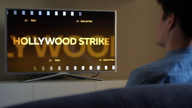 Man turn on news about Hollywood Strike on TV, Gold Film Intro Motion Graphics