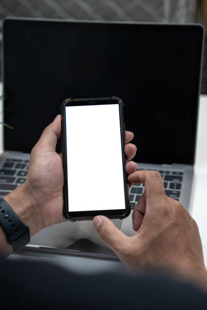 istock Man holding smartphone with blank screen, close-up of hands. Space for text. 1557991680